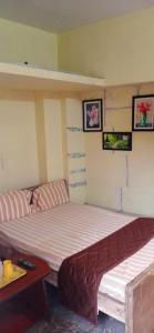a bedroom with a bed and a table and pictures at J Rooms&Dormentary in Madurai