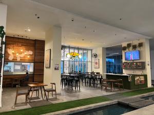 a restaurant with tables and chairs and a pool at Regalia Spritz Empire Hostel in Kuala Lumpur