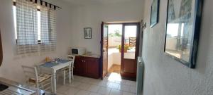 una camera con tavolo e una cucina con finestra di Case Vacanze Marina Longo a Santa Marina Salina