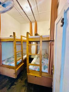 two bunk beds in a room with a door at Ijen Backpacker in Banyuwangi