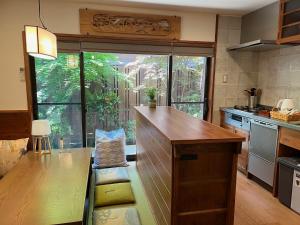 a kitchen with a wooden counter and a large window at Imakumano Terrace - Dohachi An 道八庵 in Kyoto