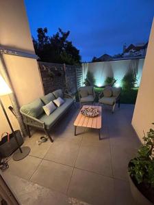 un patio con 2 sofás y una mesa de centro en Maison climatisée 155 m2+jardin, en Puteaux