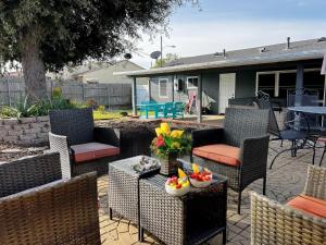 eine Terrasse mit Stühlen und einem Tisch mit Blumen darauf in der Unterkunft SeaWorld Retreat: 4BR House/Jacuzzi/BBQ in San Diego