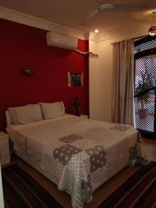 a bedroom with a large bed with a red wall at Villa Quiet Place in Luxor