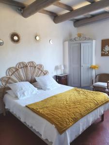 ein Schlafzimmer mit einem großen Bett und einer gelben Decke in der Unterkunft Les Tilleuls d'Elisée in Vaison-la-Romaine