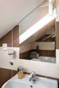 ein Badezimmer mit einem Waschbecken und einem großen Spiegel in der Unterkunft 150m² 4BR Duplex Near Metro & Prague Center in Prag