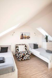 Zimmer im Dachgeschoss mit 2 Betten und einem Stuhl in der Unterkunft 150m² 4BR Duplex Near Metro & Prague Center in Prag