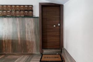 - un couloir avec une porte en bois et un tapis de bienvenue dans l'établissement Minimal Athens Apartment, à Athènes