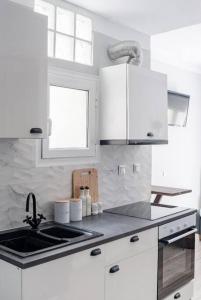 - une cuisine blanche avec des placards blancs et un évier dans l'établissement Minimal Athens Apartment, à Athènes