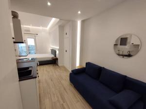 雅典的住宿－Minimal Athens Apartment，一间带蓝色沙发的客厅和一间厨房