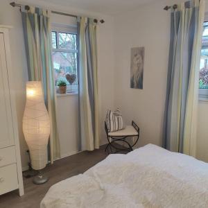 a bedroom with a bed and a chair and a window at FeWo Hope in Lindwedel