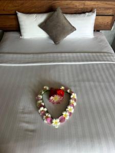 a heart shaped plate with flowers on a bed at Villa La Plantation in Kampot