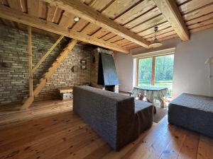 ein Wohnzimmer mit einem Sofa und einem Kamin in der Unterkunft Labanoro pasaka - Elenutės namai in Berniūnai