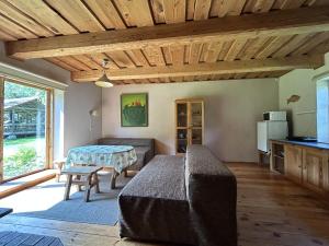 uma sala de estar com uma cama e uma mesa em Labanoro pasaka - Elenutės namai em Berniūnai