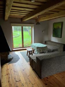 uma sala de estar com uma mesa e um sofá em Labanoro pasaka - Elenutės namai em Berniūnai