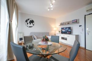 a living room with a glass table and chairs at Nuvola Apartment Fiumicino Easy Self check-in in Fiumicino