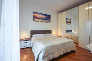 a bedroom with a large bed and a mirror at Nuvola Apartment Fiumicino Easy Self check-in in Fiumicino