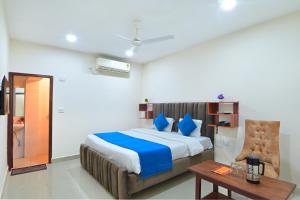 a bedroom with a bed with blue pillows and a table at Chowdhry Tourist Lodge - New Delhi Railway Station - 2 minutes walk in New Delhi