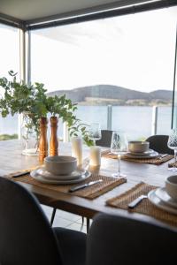 a wooden table with plates and candles on top of it at Sea View Guest House in Hobart