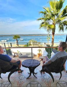 Dos personas sentadas en sillas mirando hacia el océano en En la playa, en Isla Cristina