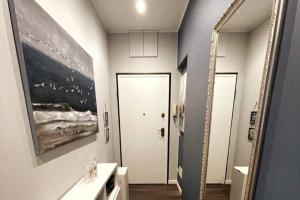 ein Badezimmer mit einem Spiegel, einem Waschbecken und einer Tür in der Unterkunft Nuovo Appartamento Borgo Coscia in Alassio