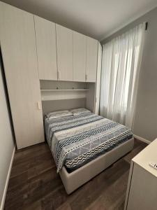 ein kleines Schlafzimmer mit einem Bett und einem Fenster in der Unterkunft Nuovo Appartamento Borgo Coscia in Alassio