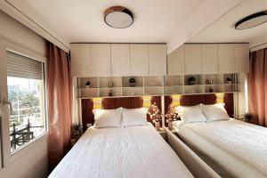 sypialnia z 2 łóżkami i oknem w obiekcie Main Square Heaven w mieście Skopje