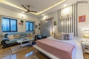 a bedroom with a bed and a couch at Ekostay - OCEAN CREST VILLA I 50 meters from Anjuna Beach in Vagator