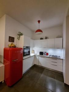 eine Küche mit einem roten Kühlschrank und weißen Schränken in der Unterkunft A casa di Cesare in Rom