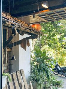 eine Holzbank unter einer Veranda mit Beleuchtung in der Unterkunft Hostel-John Cafe and Beer in Da Lat