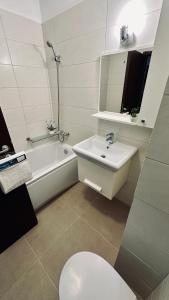 a bathroom with a sink and a tub and a toilet at Bonjour Residence with terrace and parking in Cluj-Napoca +23 photos