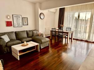 a living room with a couch and a table at Bonjour Residence with terrace and parking in Cluj-Napoca