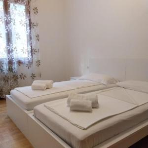 Dos camas en una habitación con toallas. en Casa Gabriel, en Toscolano Maderno