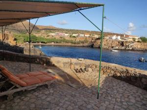 a chair sitting under an umbrella next to a river at Casa Tartaruga in Carriçal