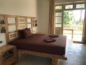 Hiriketiya的住宿－Wilson's Place，一间卧室设有一张大床和大窗户
