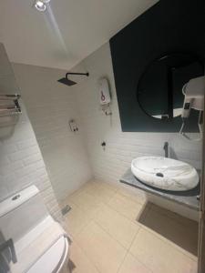 ein Bad mit einem WC und einem Spiegel in der Unterkunft Seeds Hotel Chow Kit in Kuala Lumpur