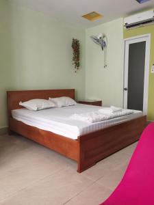 um quarto com uma cama grande e lençóis brancos em MOTEL WIN - PHÁT em Bien Hoa