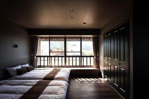 Itoshima810 Villa & Resort - Vacation STAY 13917 في Itoshima: سرير في غرفة مع نافذة كبيرة