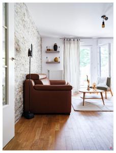 sala de estar con sofá marrón y mesa en Magnifique F3 Classé 3 Étoiles à 20 min de Paris & Disney, en Villiers-sur-Marne