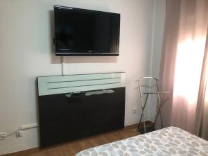 una TV a schermo piatto appesa a un muro di Apartamento Villa Caracol a Cunit