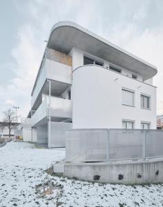 um edifício com neve no chão à sua frente em Wohnen in Wattens Top 3 em Wattens