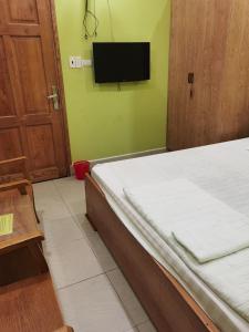 um quarto com uma cama e uma televisão de ecrã plano em MOTEL WIN - PHÁT em Bien Hoa
