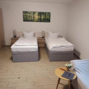 Habitación con 2 camas y mesa. en Ferienhaus Magasch, en Mittenwalde