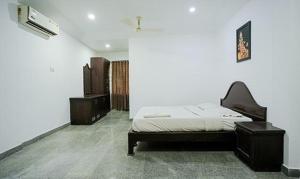 a bedroom with a bed and two dressers at FabHotel Lime Light in Cochin