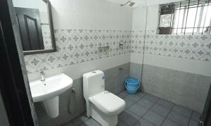 a bathroom with a toilet and a sink at FabHotel Lime Light in Cochin