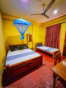 a bedroom with two beds and a blue umbrella at Green Star Safari Home in Udawalawe