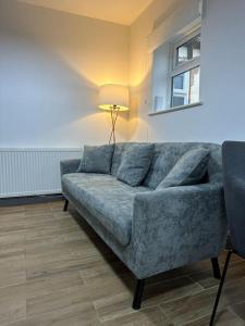 sala de estar con sofá azul y lámpara en Modern 2 Bed Flat In Derby City en Derby