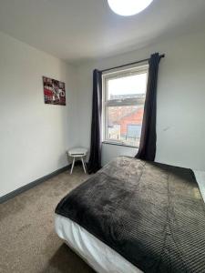 a bedroom with a large bed and a window at Modern 2 Bed Flat In Derby City in Derby