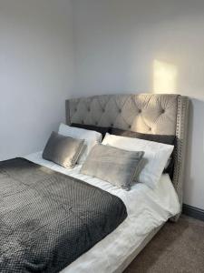 a bed with pillows on it in a room at Modern 2 Bed Flat In Derby City in Derby