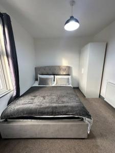 a bedroom with a large bed in a white room at Modern 2 Bed Flat In Derby City in Derby